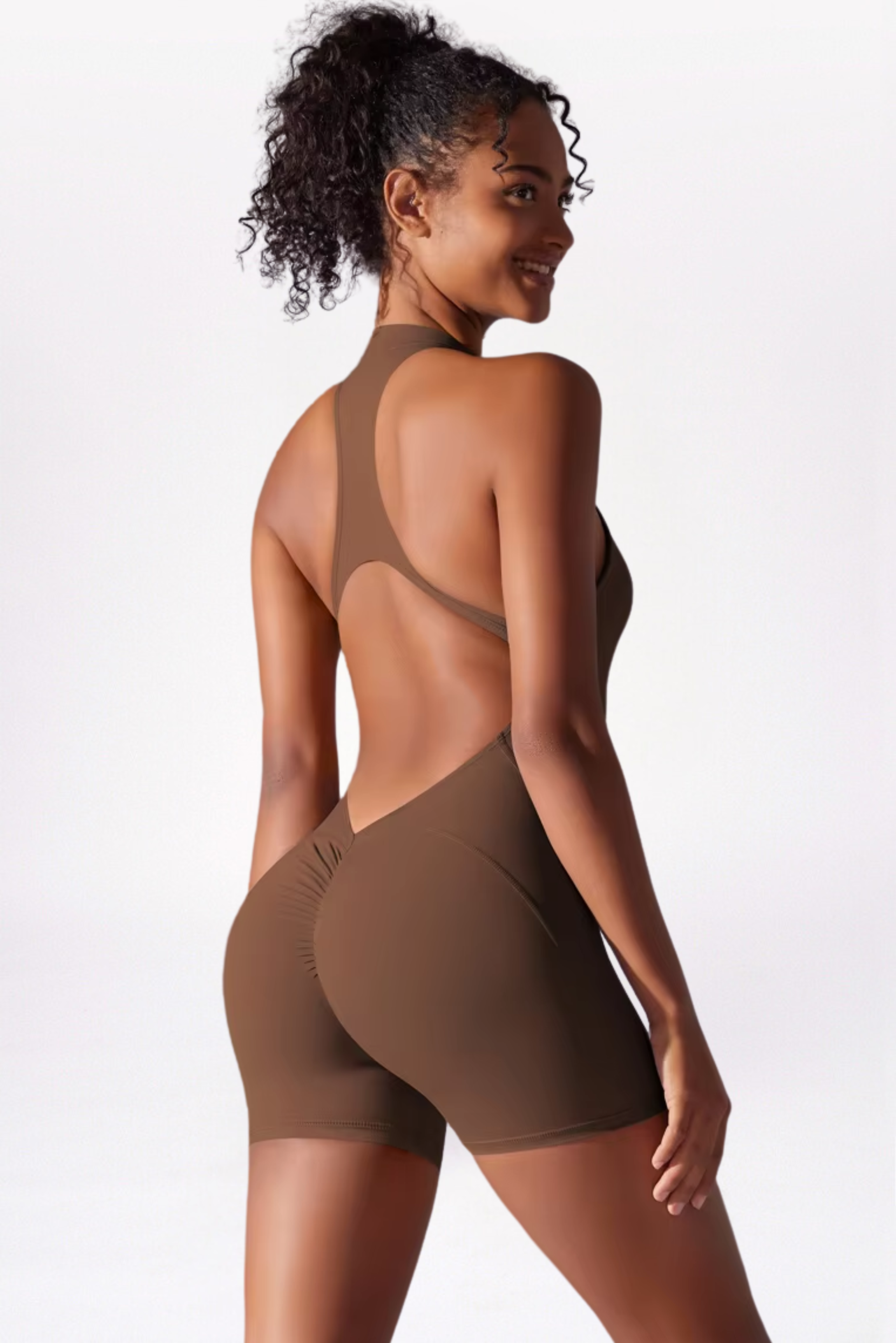 Woman wearing a brown bodysuit with cut-out design on a white background