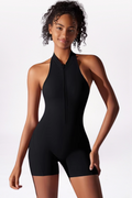 Woman wearing a black halter neck swimsuit against a white background
