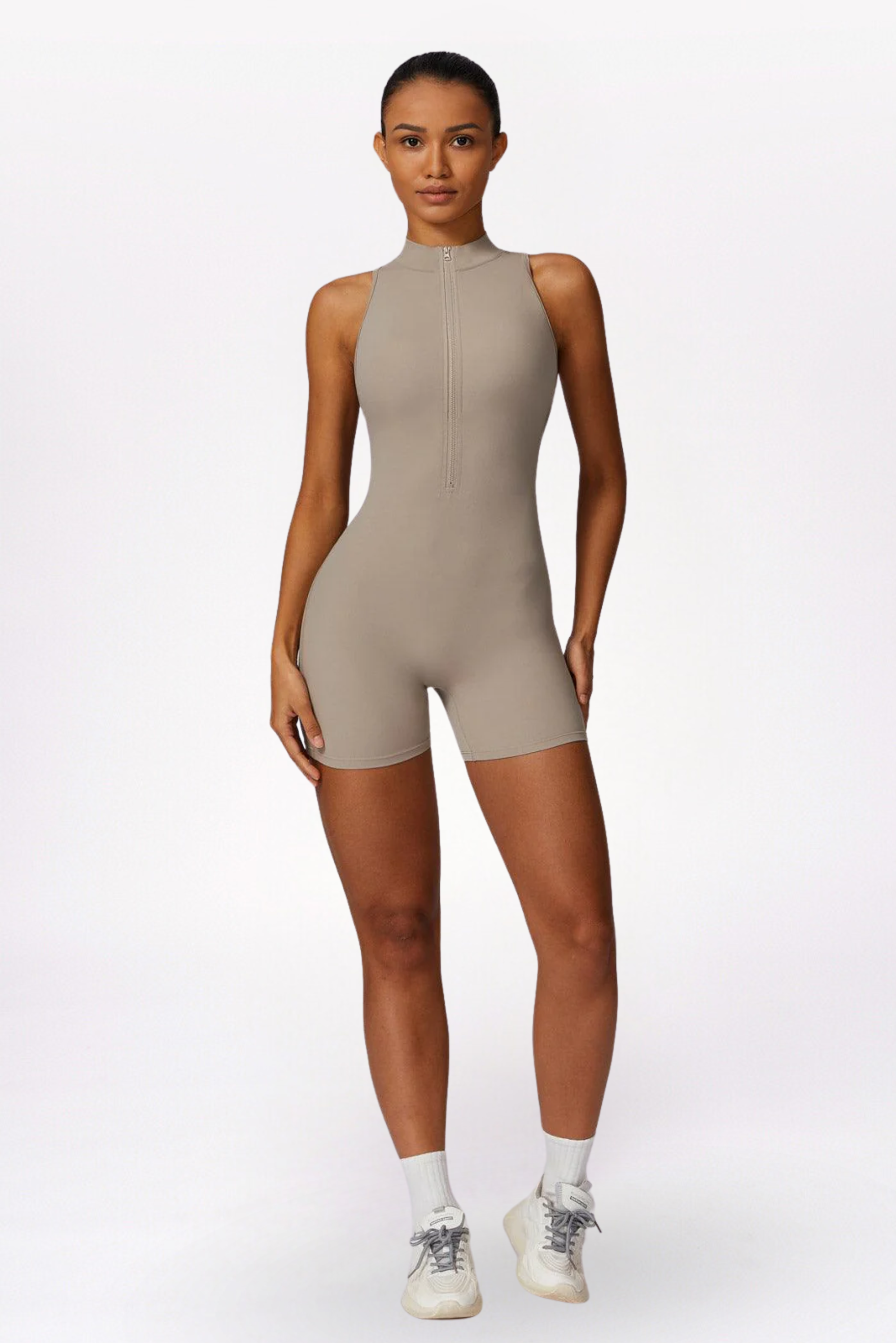 Woman wearing a beige bodysuit on a white background brand Gymelle