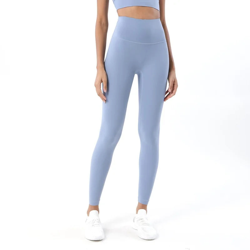 Person wearing light blue leggings and a matching top on a white background