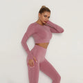 Woman wearing a pink knit outfit against a white background