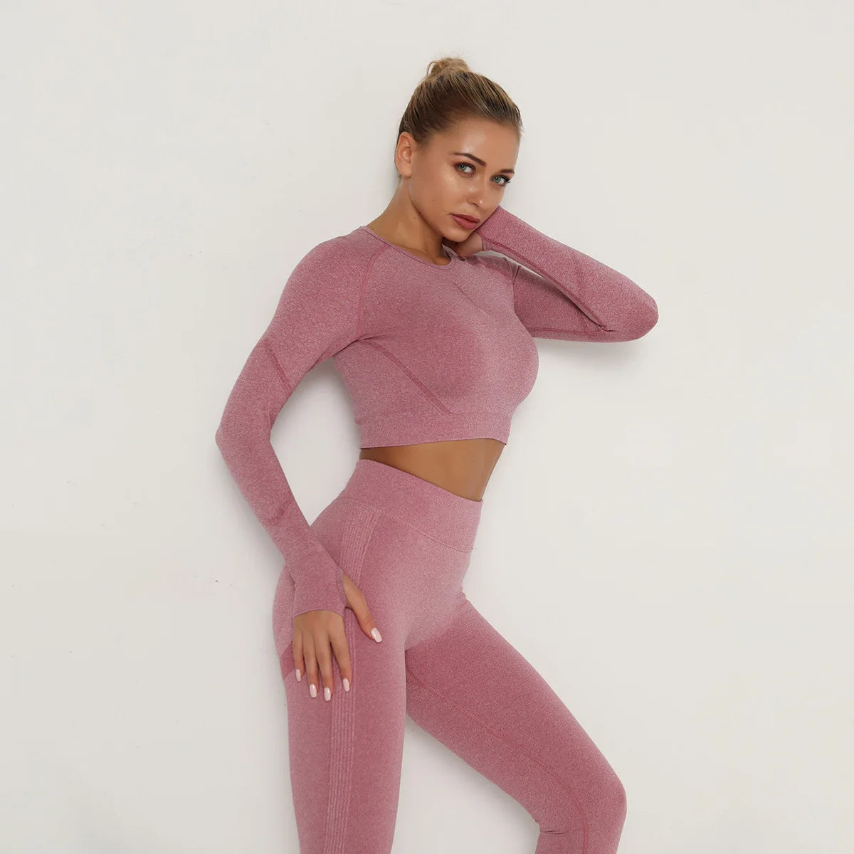 Woman wearing a pink knit outfit against a white background