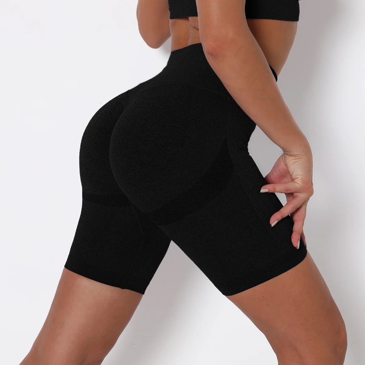 Person wearing black shorts on a plain background